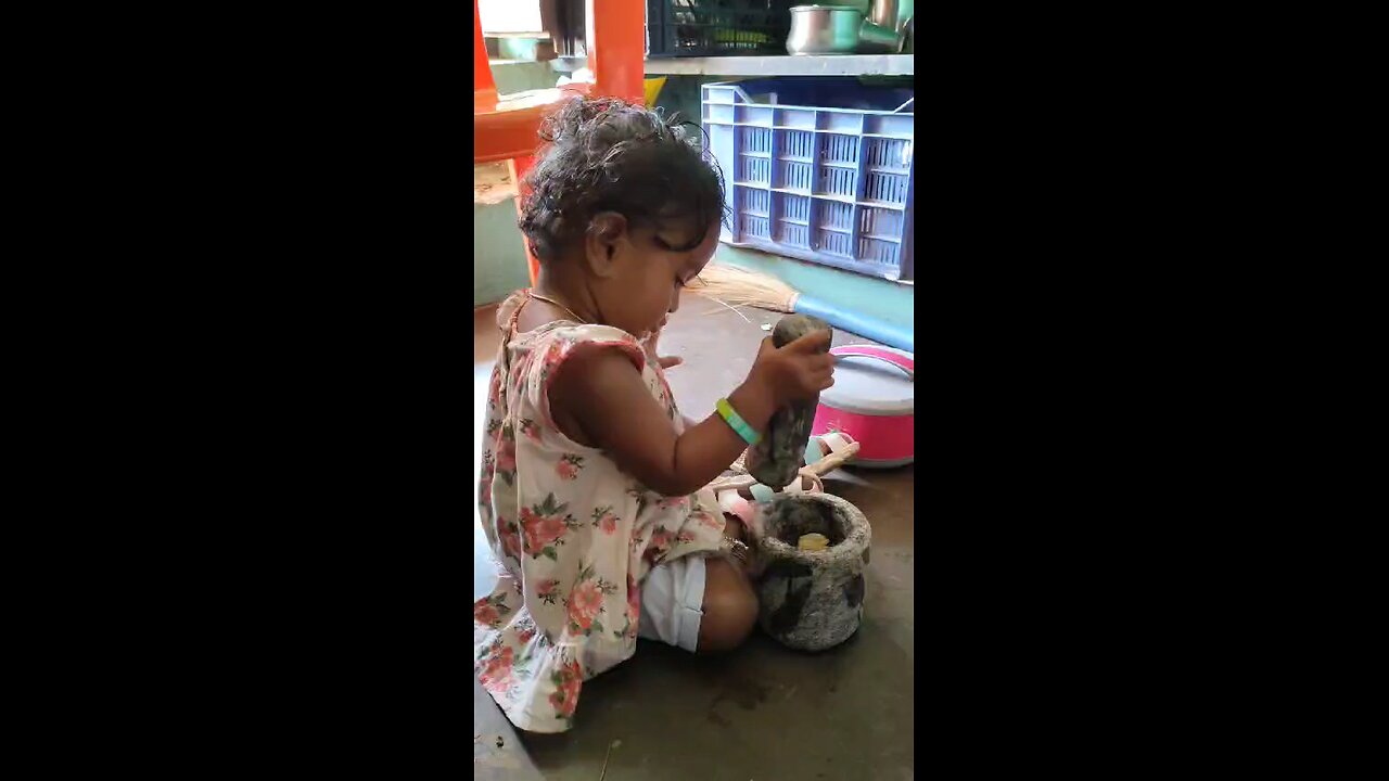 Cute baby learning traditional Indian Tamil cooking procedure