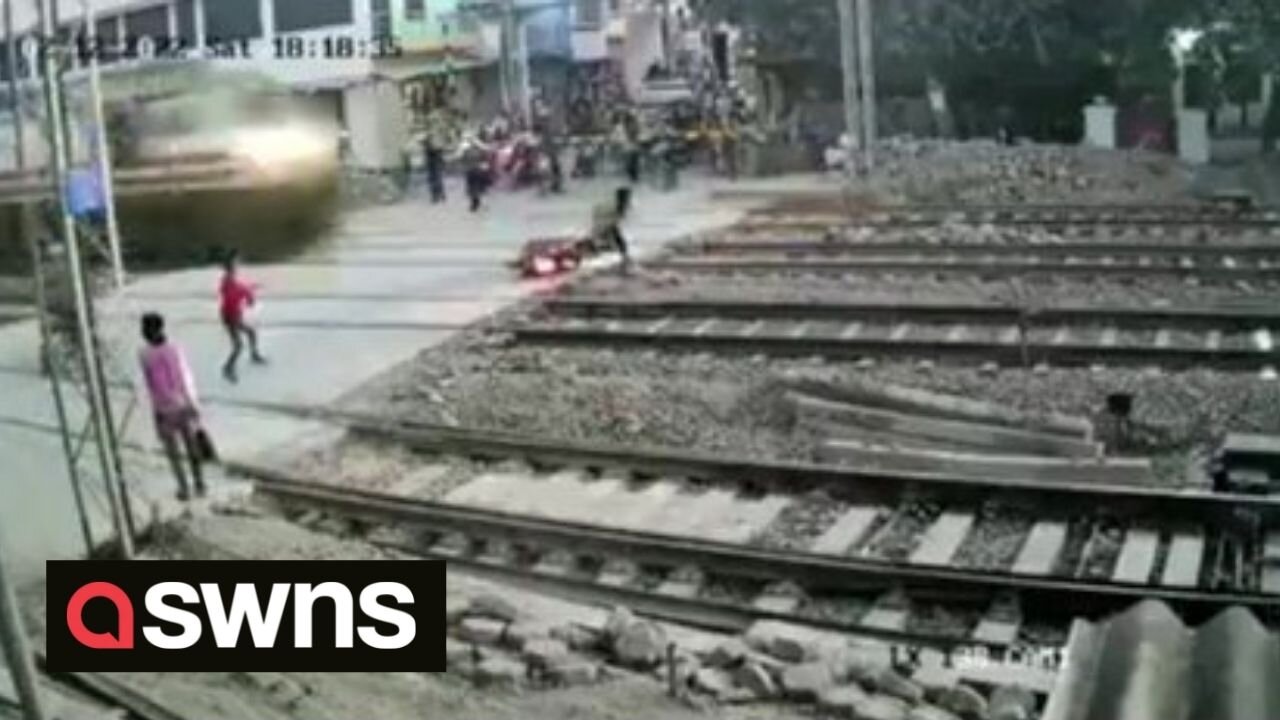 FURTHER FOOTAGE: Shocking moment man barely misses ONCOMING TRAIN at level crossing