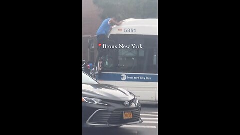 Guy getting on top of bus in New York