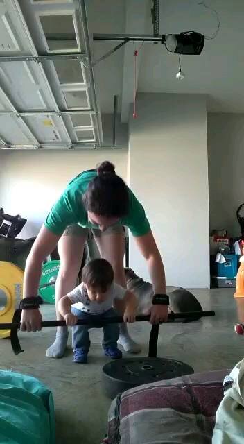 Toddler learning to deadlift with a weight bar