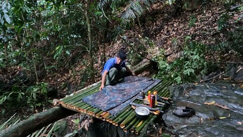 Building a bamboo shelter on a rock face:2