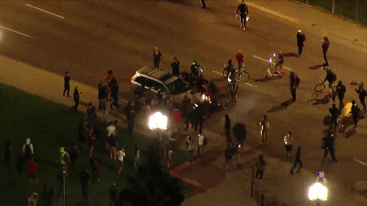 Man detained after hitting protesters with his car, police say