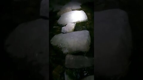 crossing the the river Lyd over the stepping stones at night. Dartmoor