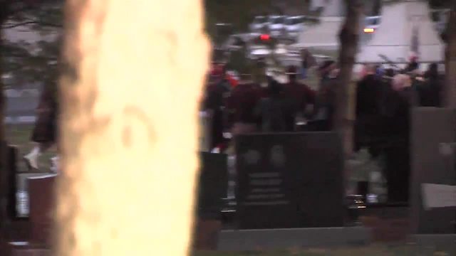 Bagpipes play as the hearse carrying Dep. Jacob Pickett arrives at Crown Hill Cemetery