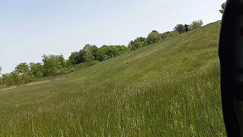 Carrying A 50 LB Slamball Up Hill And Over The Shoulder Throw, In High Grass And Wet Grass.