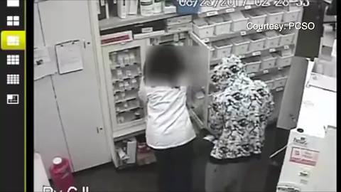 Robber threatens to shoot pharmacist in the head if she makes a sound; suspect on the run