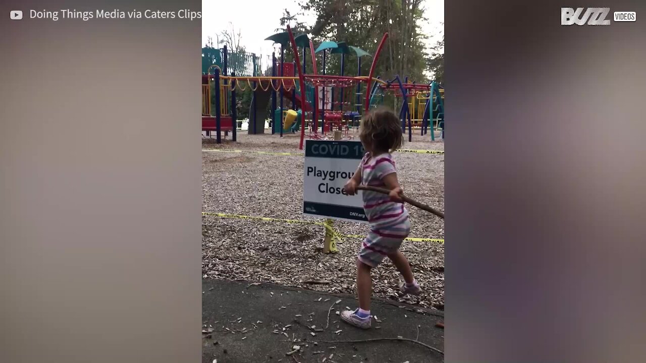 Criança tenta destruir placa que avisa que o parque está fechado