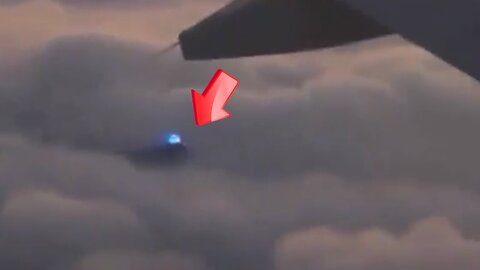 A glowing blue UFO peeks out of an aircraft window [Space]