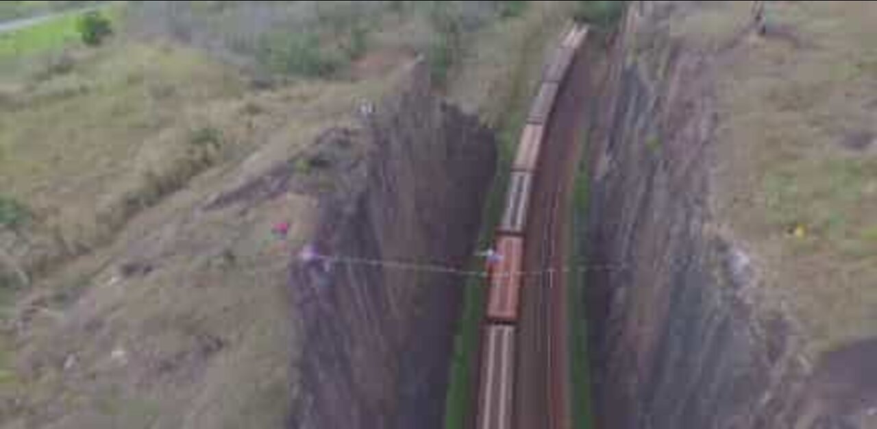 Atleta de Slackline atravessa por cima de linha ferroviária