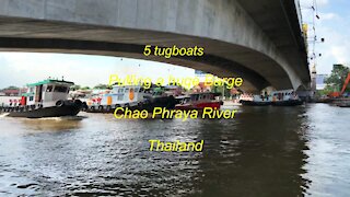 5 tugboats pulling a barge at Chao Phraya river in Thailand