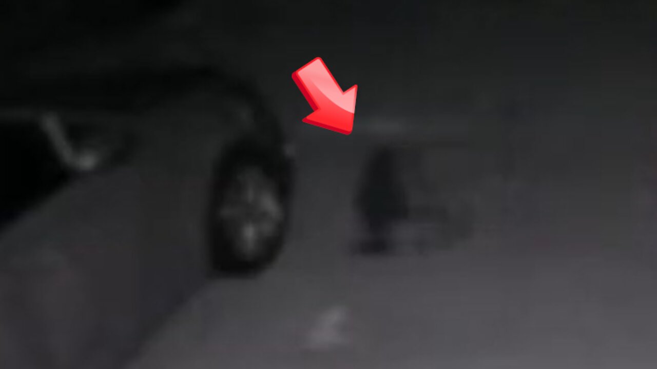 A dwarf looking for something near an automobile [Conspiracy]