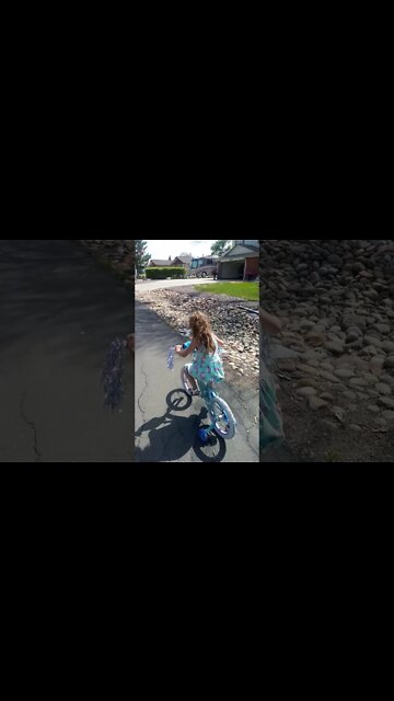 Learning to use the brakes while riding her bicycle.