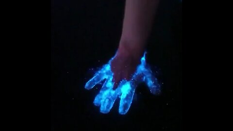 A hand being dipped in bioluminescent water Wow!