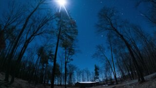 Moon and star night lapse from forest mountain cabin