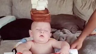 Ce papa met des aliments en équilibre sur la tête de son bébé endormi