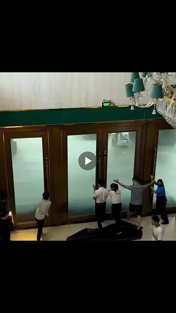 Hotel workers try to hold open doors hit by powerful gusts of wind from super typhoon.