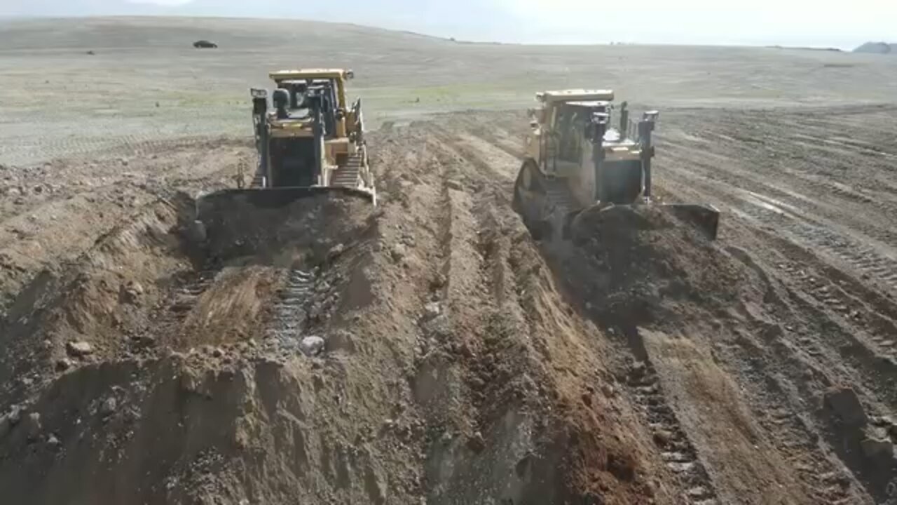 GIGANTIC BULLDOZERS PUSHING DIRT