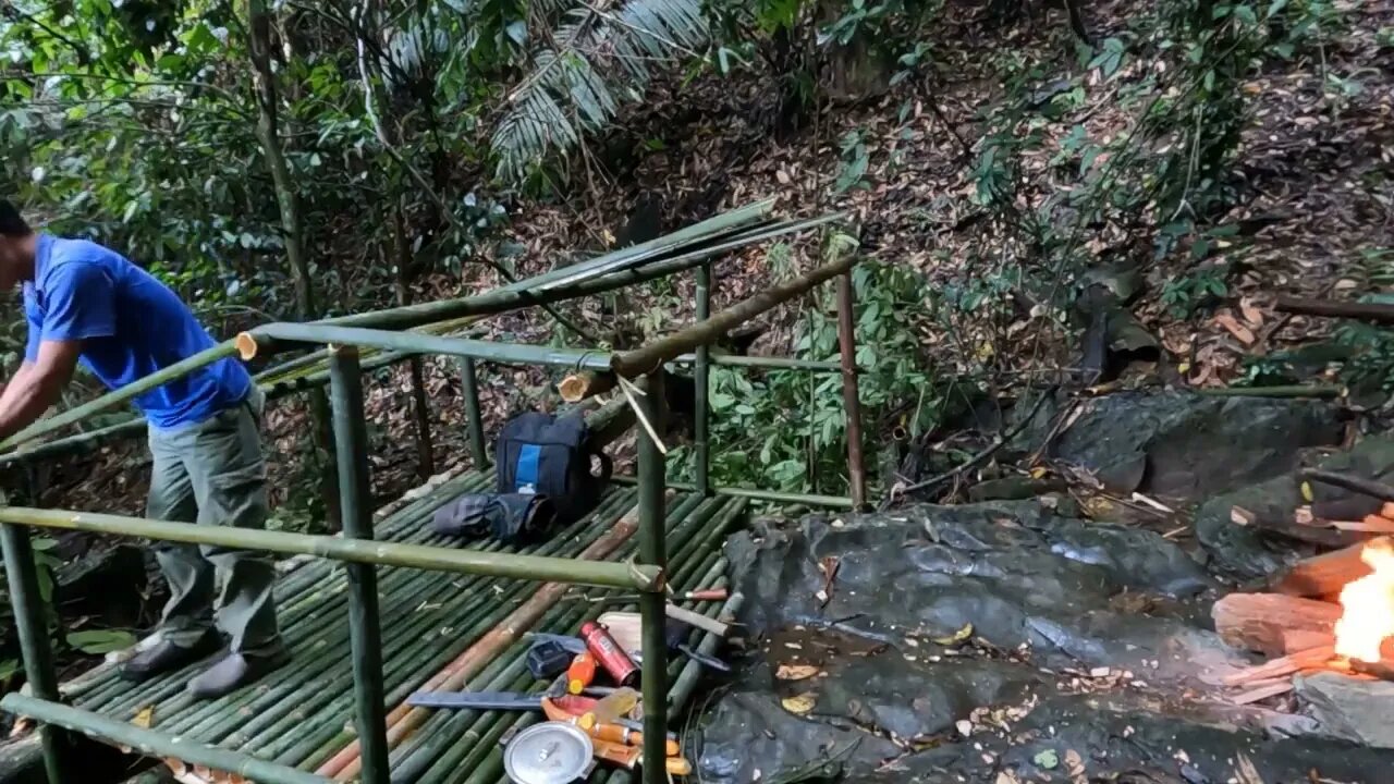 Building a bamboo shelter on a rock face:17