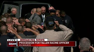 Fellow officers carry fallen officer John Hetland's body to Milwaukee County Medical Examiner's Office