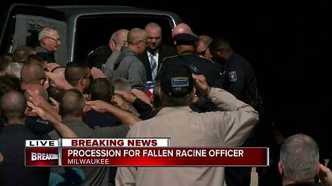 Fellow officers carry fallen officer John Hetland's body to Milwaukee County Medical Examiner's Office