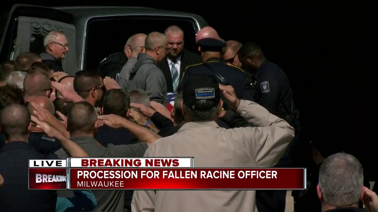 Fellow officers carry fallen officer John Hetland's body to Milwaukee County Medical Examiner's Office