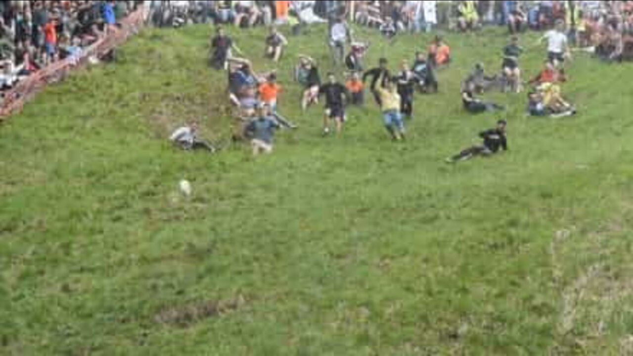 People from around throw themselves down a hill for cheese