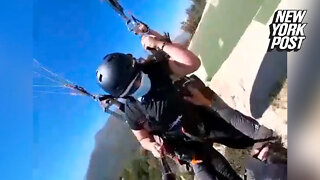 Paragliding worker hangs on for his life by his bare hands