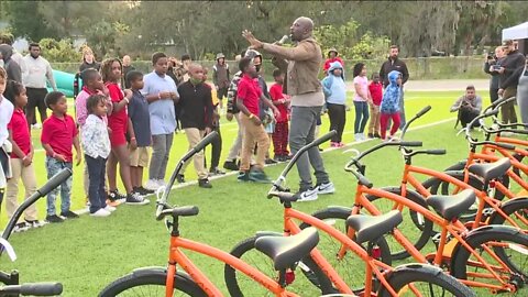 Two football teams competing in the Gasparilla Bowl build bicycles for students in Tampa