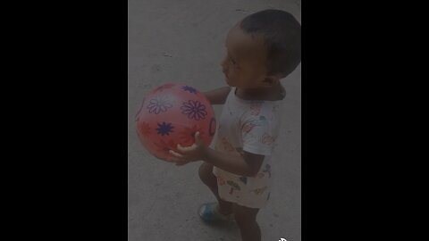 The joy of a child playing football in the street