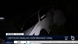 Car found dangling over drainage canal