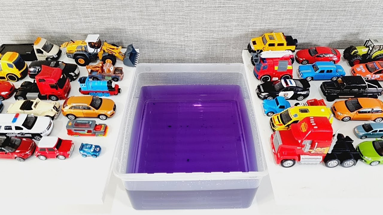 Diecast Model Cars Sliding Into The Purple Water.