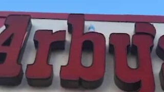 Jovem executa “bottle flip challenge” em letreiro de restaurante