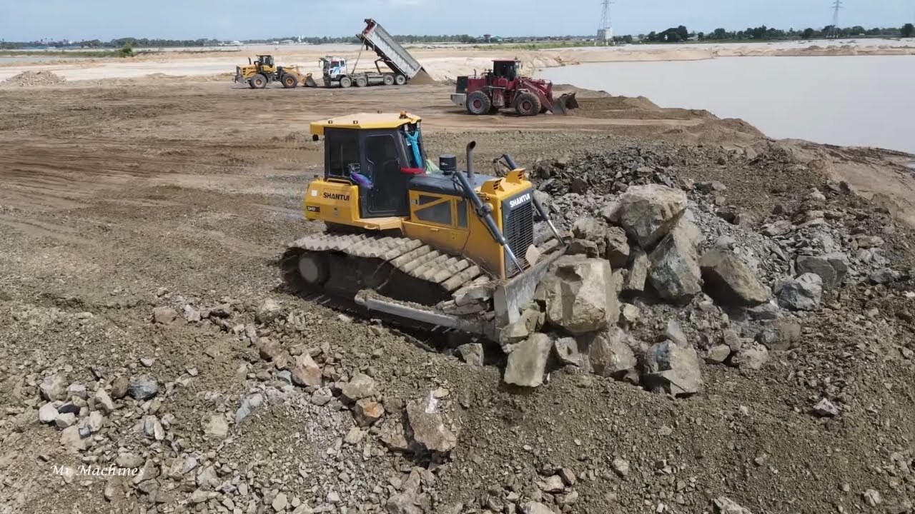 Satisfy operation new SHANTUI bulldozer pushes rock stone in land reclamation on lake