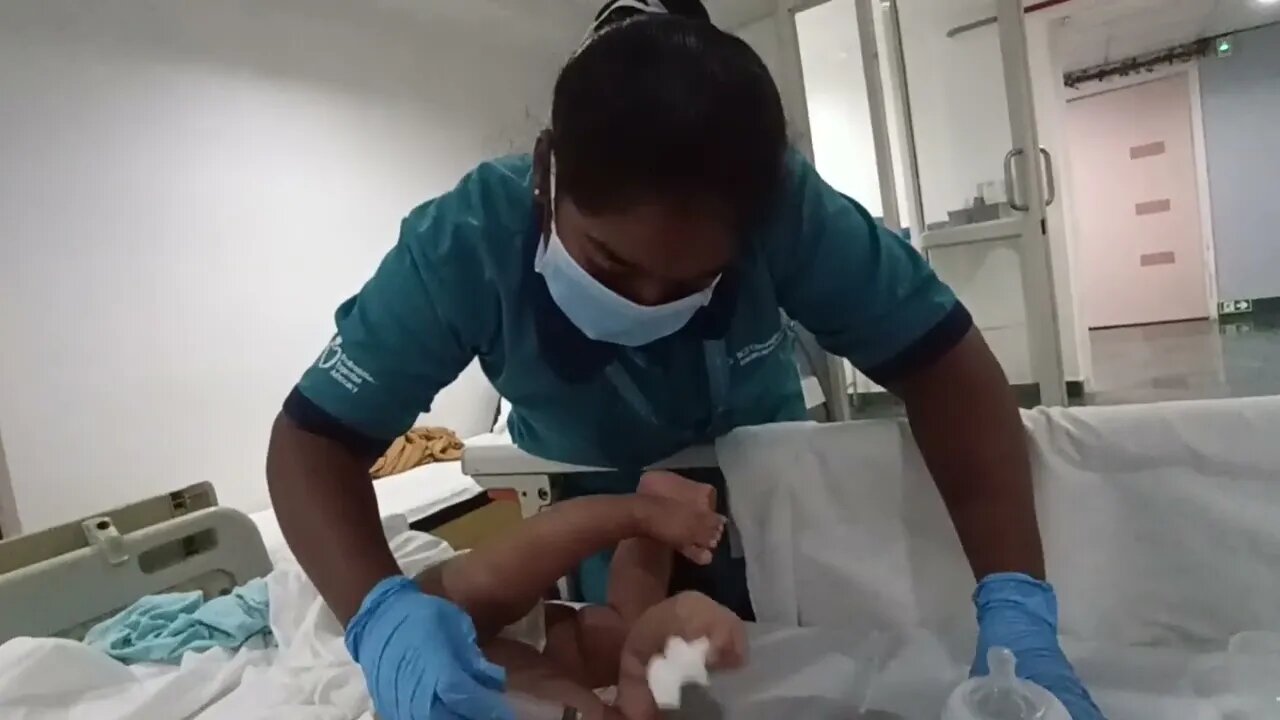 nurse trying to feed 5 months old baby while mother is hospitalized