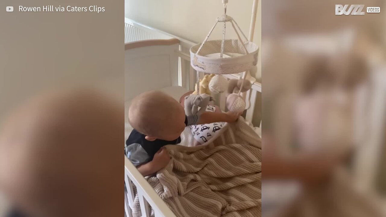 Toddler hugs little brother as he sleeps