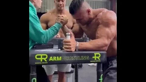 Teenager arm wrestles body builder