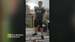 'Pretty wicked eh?' man wears t-shirt and shorts in a hailstorm