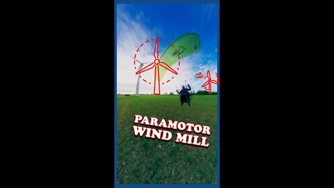 Paramotor flying near wind mill