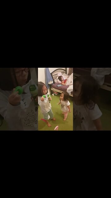 Baby girls play with bubbles while mommy chills doing phone