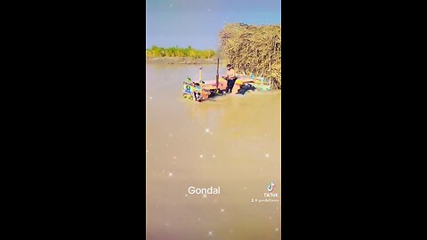 Tractor crossing river with fully load