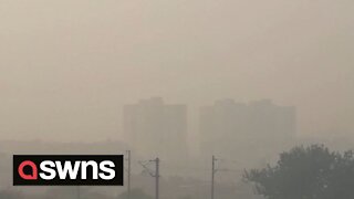 Thick fog plunges fields and tower blocks in India into darkness
