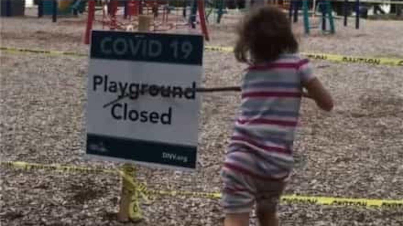 Criança tenta destruir placa avisando que o parque está fechado