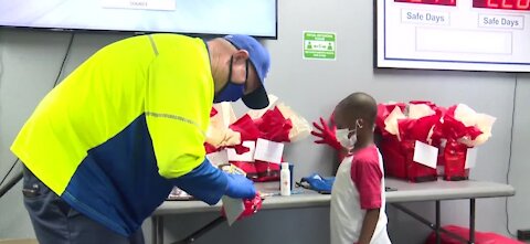 Little boy puts together thank you bags for sanitation workers