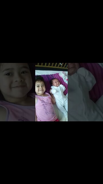 Baby girl is taking care of her new born baby sis