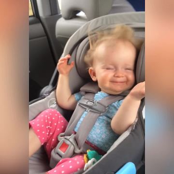 A Baby Girl Laughs As The Wind Blows Back Her Hair