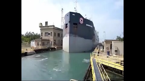 Large cargo ship passing through small canal