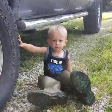 Little Boy Tries On Dad's Boots