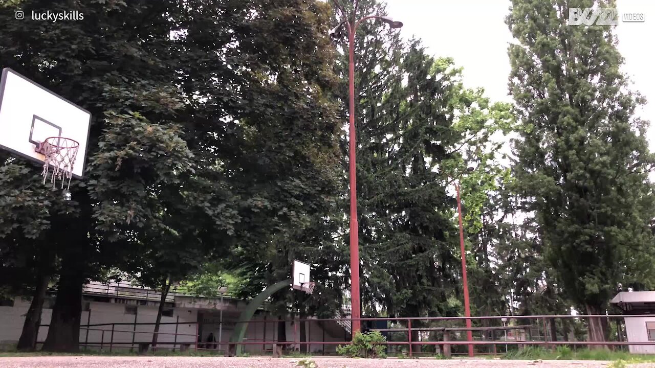 Jovem encesta bola de basquetebol de forma incrível