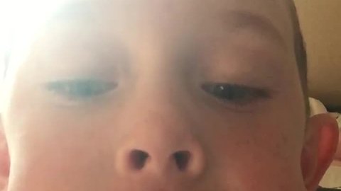 Kid bravely pulls out his first loose tooth