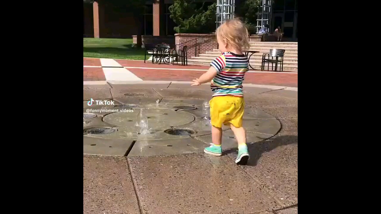Splash Fun joyful toddler playing with water, their face beaming with excitement as they splash